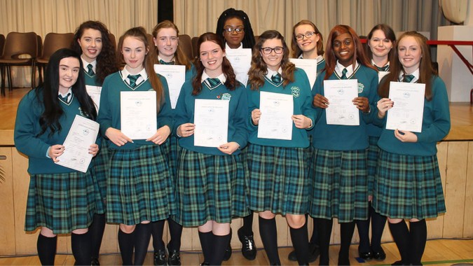 Schülerinnen und Schüler der St. Paul’s Secondary in Galway halten auf einer Bühne ihre Auszeichnungen in einer feierlichen Veranstaltung.