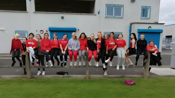 Eine Gruppe Schülerinnen steht vor einem Gebäude mit blauen Akzenten auf dem Gelände der St. Paul's Secondary School in Kildare.