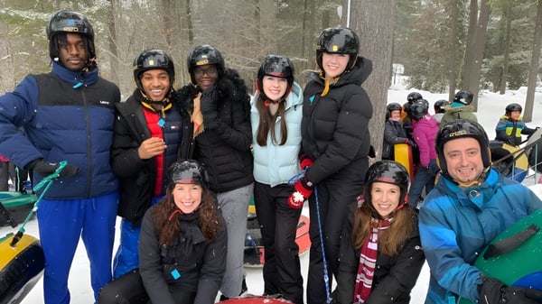 Eine Gruppe von Schülerinnen und Schülern der St. Peter Catholic High School steht im verschneiten Wald und trägt Winterkleidung sowie Helme.