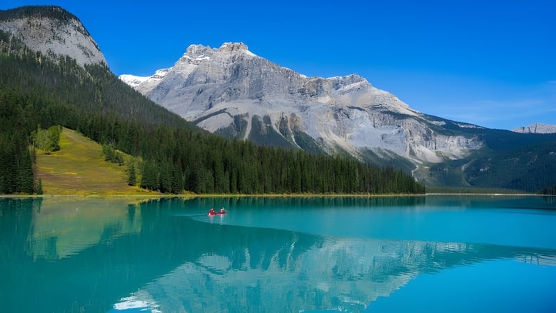 Zwei Schülerinnen paddeln mit Kajaks auf einem alpinen See in der Nähe der St. Peter Catholic High School.