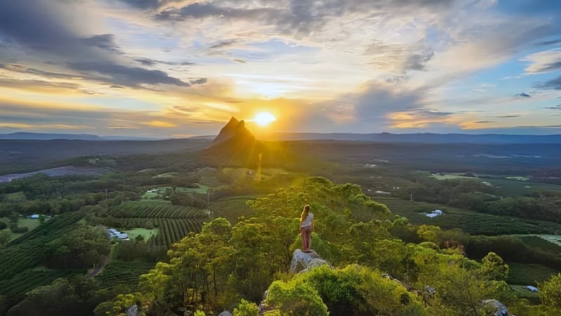 Luftaufnahme einer grünen Landschaft mit einem markanten Felsen im Hintergrund beim St. Peters Lutheran College.