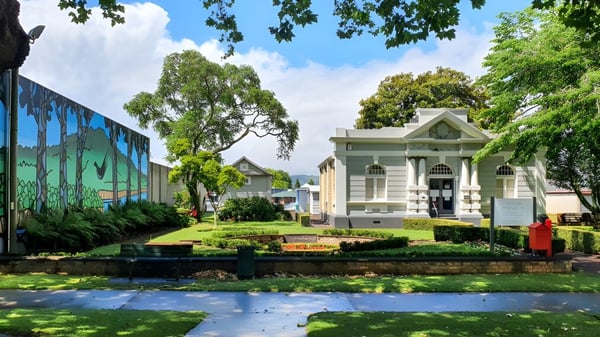 Ein historisches Gebäude der St. Peter's School Cambridge ist von einem gepflegten Garten mit üppigem Grün umgeben.