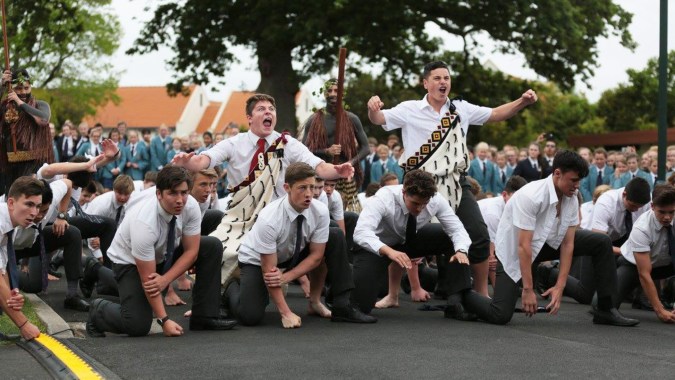 Eine Gruppe Schüler der St. Peter's School Cambridge steht im Freien vor Bäumen und Gebäuden.