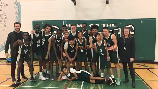 Die Basketballmannschaft der St. Pius X High School posiert gemeinsam in der Sporthalle.