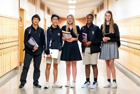 Eine Gruppe Schüler steht im Flur mit Schließfächern auf dem Campus der St. Pius X High School.