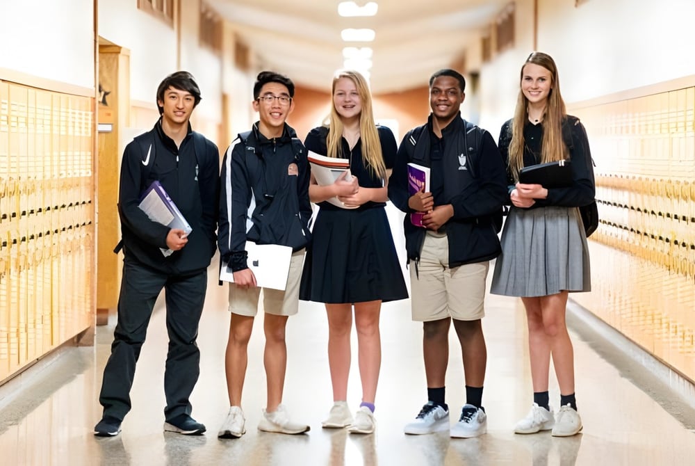 Eine Gruppe Schüler steht im Flur mit Schließfächern auf dem Campus der St. Pius X High School.