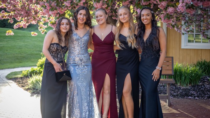 Fünf Schülerinnen der St. Raphaela’s Secondary School stehen gemeinsam in einem blühenden Garten.