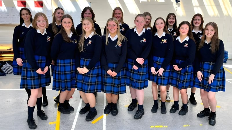 Eine Gruppe von Schülerinnen der St. Raphaela’s Secondary School steht gemeinsam vor einem Gebäude mit großen Fenstern.