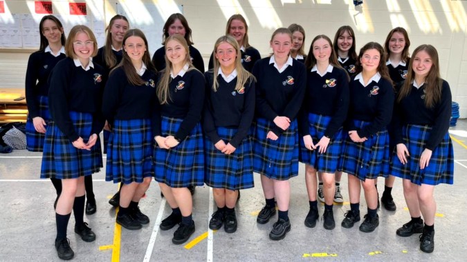 Eine Gruppe Schülerinnen in Schuluniformen steht gemeinsam im Flur der St. Raphaela’s Secondary School.