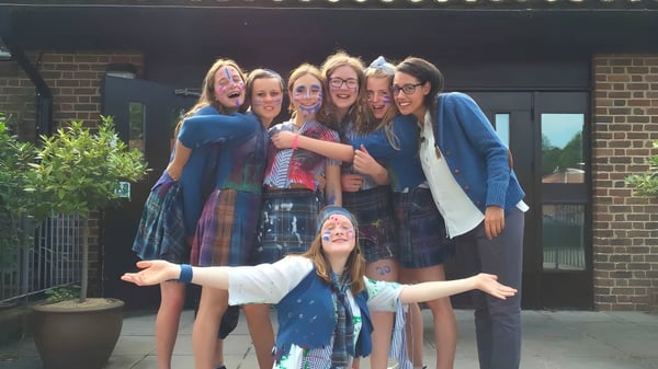 Eine Gruppe von Schülerinnen steht vor einem Backsteingebäude auf dem Campus der St. Swithun's School.