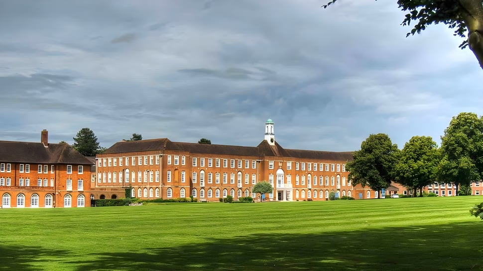 Das große Backsteingebäude mit zentralem Turm steht auf dem grünen Campus von St. Swithun's.