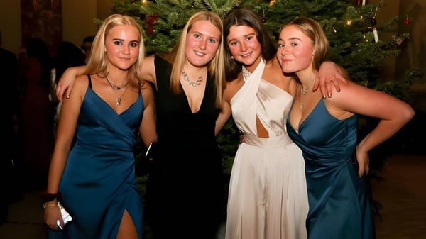 Vier Schülerinnen des St. Teresa’s College stehen gemeinsam vor einem geschmückten Weihnachtsbaum.