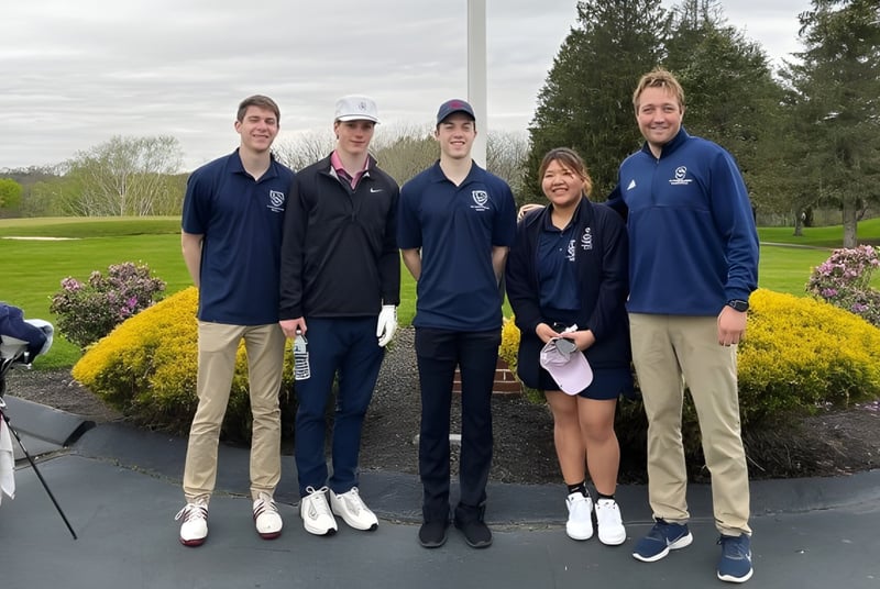 Eine Gruppe von Schülern der St. Thomas More School steht gemeinsam im Park mit Bäumen und Grünflächen im Hintergrund.