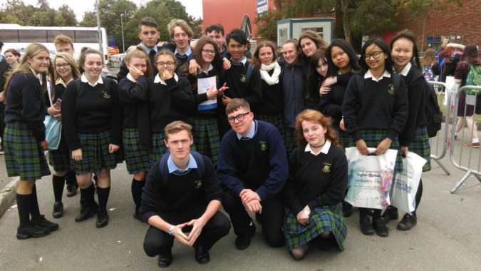 Schülerinnen und Schüler von St. Tiernan’s College stehen im Freien vor Bäumen und Gebäuden.