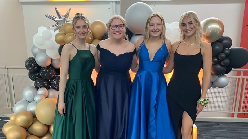 Vier Schülerinnen der St. Timothy High School posieren vor einem Hintergrund aus bunten Luftballons.