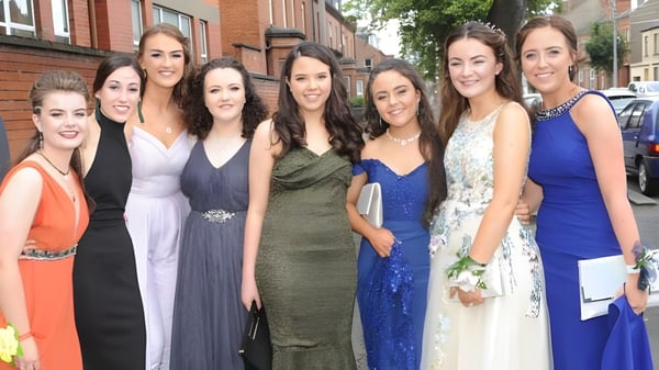 Eine Gruppe junger Frauen in formeller Kleidung posiert vor einem Backsteingebäude auf dem Campus der St. Vincent's Secondary School.