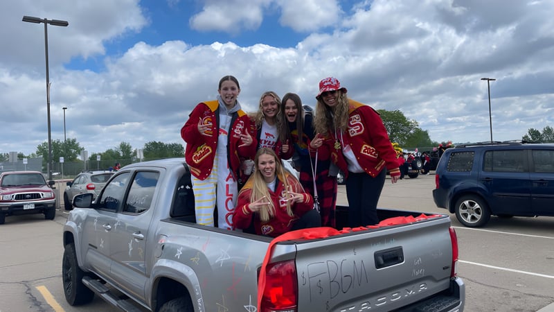 Eine Gruppe Schüler in roten Uniformen steht auf der Ladefläche eines Pickups auf dem Gelände der St. Vrain Valley Schools.