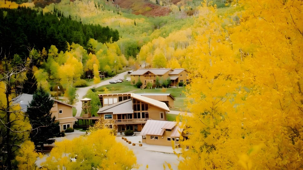 Eine malerische Berglandschaft mit buntem Laub und einer gewundenen Straße in der Nähe der Steamboat Mountain School.