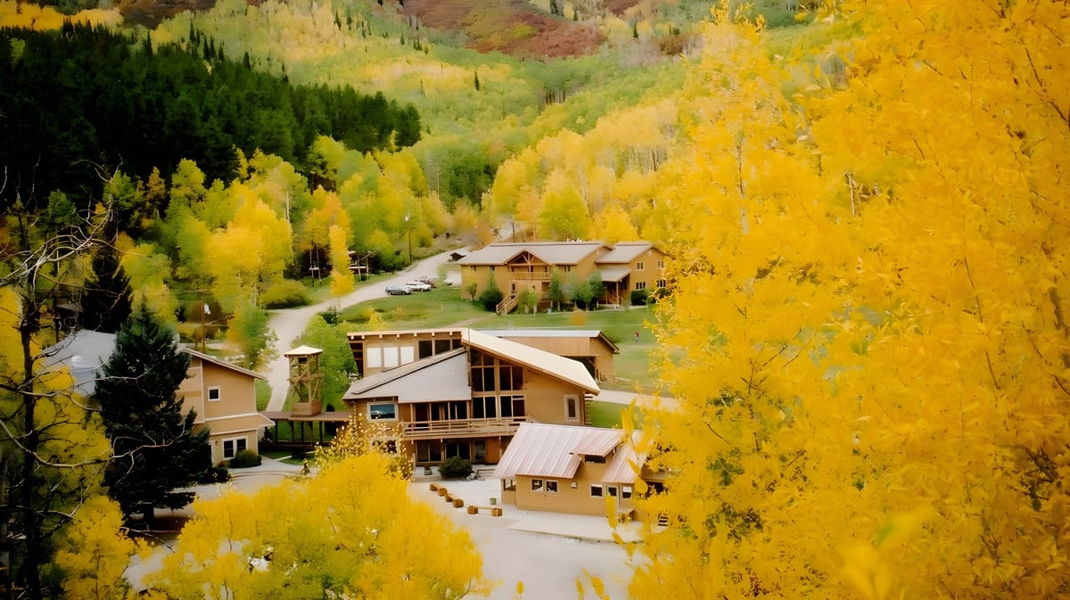 Eine malerische Berglandschaft mit buntem Laub und einer gewundenen Straße in der Nähe der Steamboat Mountain School.