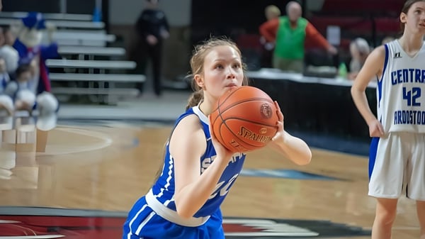 Eine junge Basketballspielerin der Stearns High School dribbelt den Ball auf dem Basketballfeld.