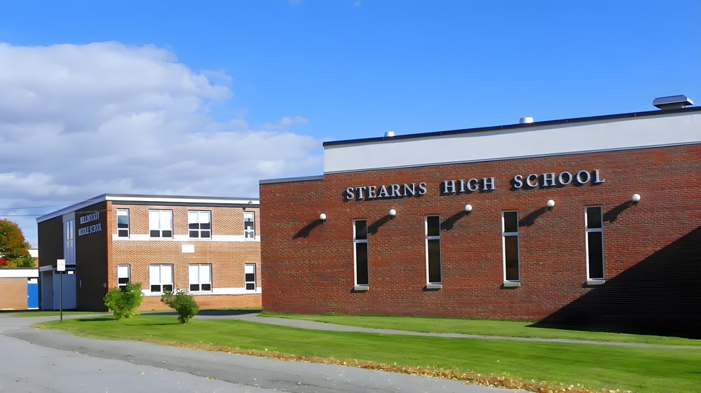 Das Backsteingebäude der Stearns High School bei blauem Himmel mit Wolken.