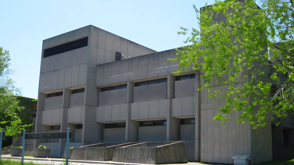Das moderne Schulgebäude des Stephen Leacock Collegiate Institute mit großen Fenstern und einem markanten Eingang ist von grünen Bäumen umgeben.