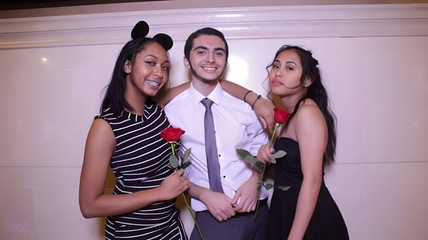 Drei Personen posieren gemeinsam auf dem Campus des Stephen Leacock Collegiate Institute in einem Innenbereich.