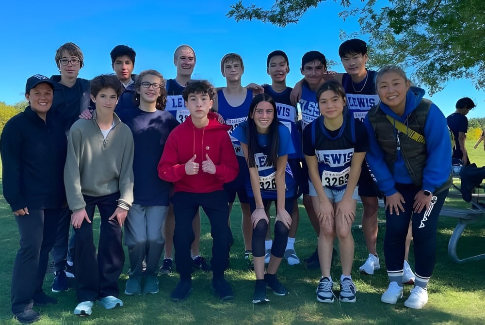 Eine Gruppe von Schülerinnen und Schülern steht gemeinsam im Freien auf dem Gelände der Stephen Lewis Secondary School.