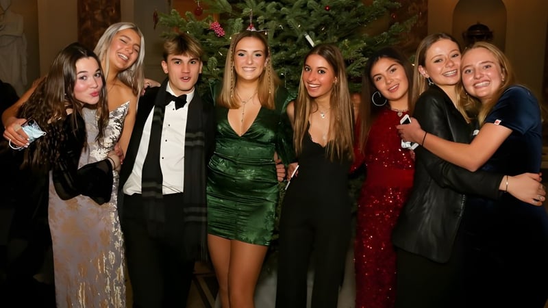 Schüler der Stephen Perse Foundation posieren gemeinsam vor einem geschmückten Weihnachtsbaum.