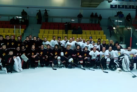 Eine Gruppe von Schülern der Stephenville High School steht in Sportkleidung auf dem Eishockeyfeld für ein Gruppenfoto.
