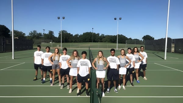 Eine Gruppe von Schülerinnen und Schülern der Stephenville High School steht gemeinsam auf einem Tennisplatz vor einem Rasenfeld mit Bäumen.