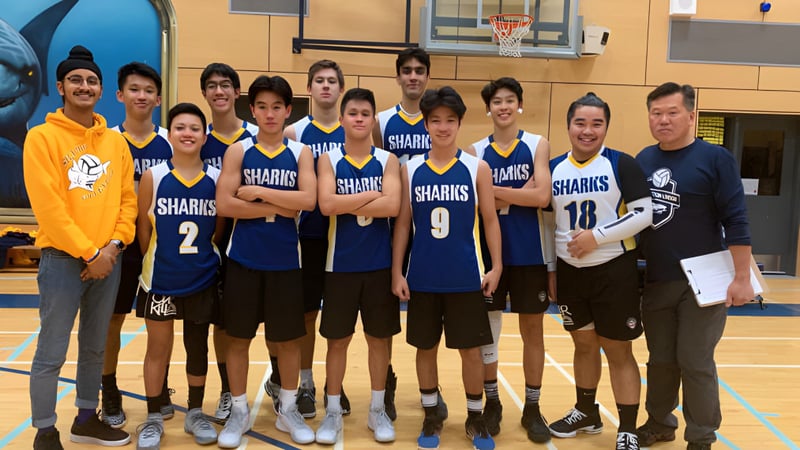 Die Basketballmannschaft der Steveston-London Secondary School steht gemeinsam in der Sporthalle mit passenden Trikots.