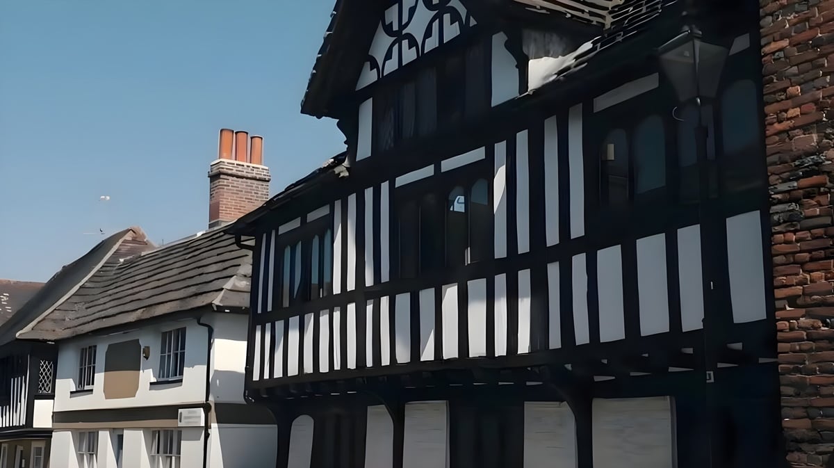 Das historische Fachwerkgebäude auf dem Campus der Steyning Grammar School and Sixth Form steht vor klarem blauem Himmel.