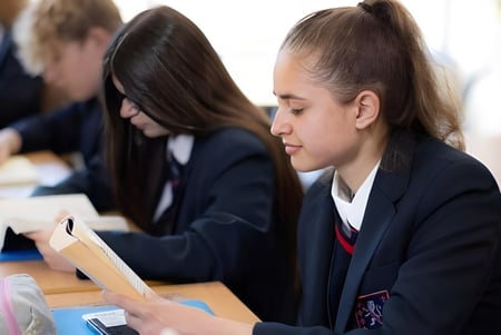 Schüler der Steyning Grammar School and Sixth Form sitzen im Klassenraum an Tischen und arbeiten an ihren Aufgaben.