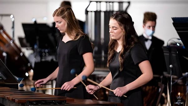 Zwei Schülerinnen der Stillwater Christian School spielen auf der Bühne Schlaginstrumente.