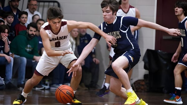 Zwei Basketballspieler konkurrieren um den Ball auf dem Spielfeld der St. Mary’s Diocesan School vor Zuschauern.