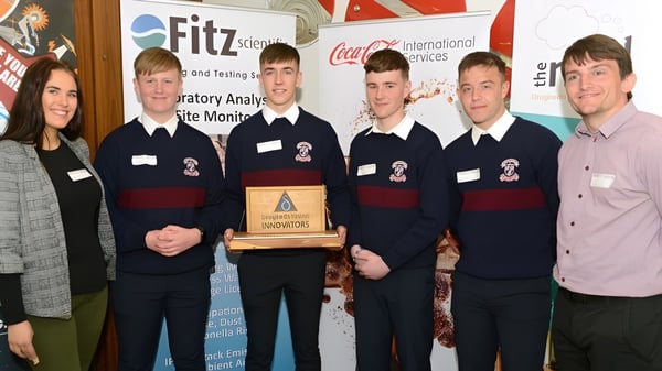 Schüler der St. Mary’s Diocesan School halten eine Trophäe vor einem Fitz-Logo und feiern ihren Wettbewerbserfolg.