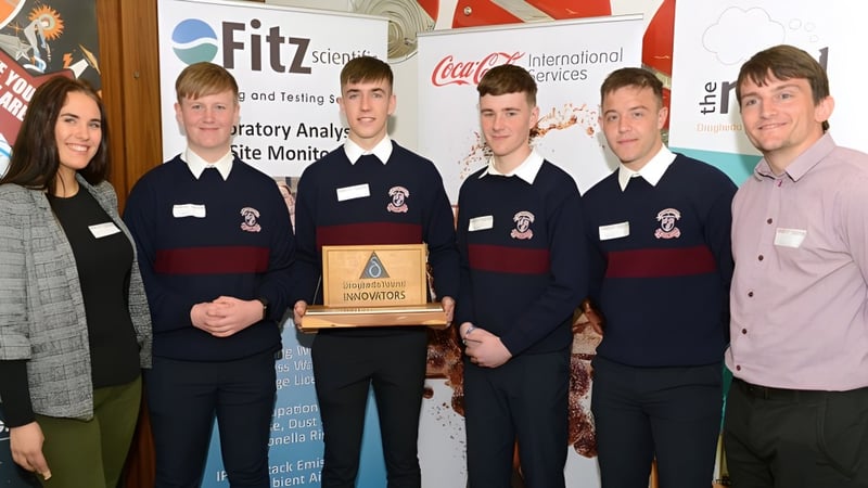 Schüler der St. Mary’s Diocesan School halten eine Trophäe vor einem Fitz-Logo und feiern ihren Wettbewerbserfolg.