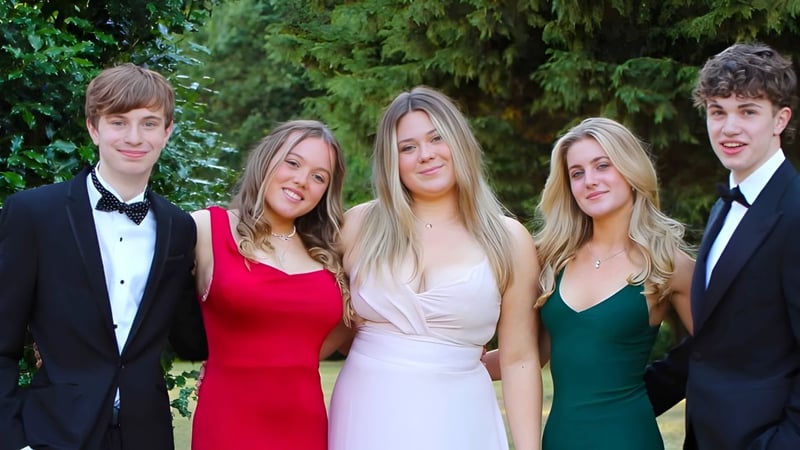 Eine Gruppe von fünf jungen Erwachsenen in formeller Kleidung posiert im Wald auf dem Gelände des Stoke College.