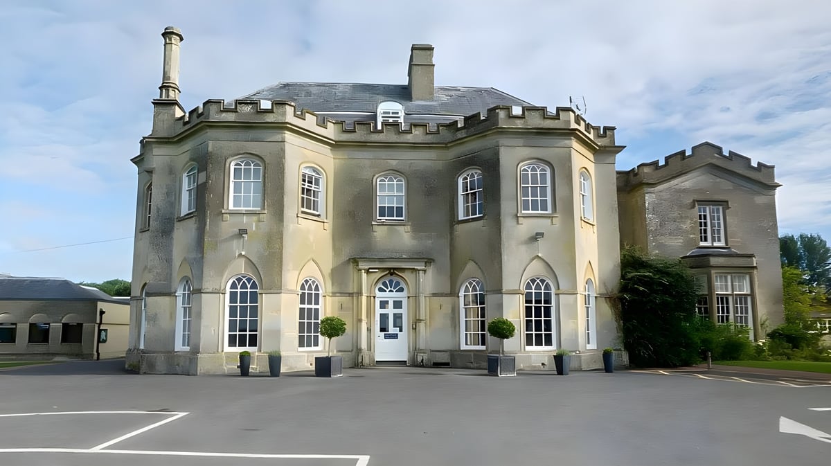Das Gebäude der Stonar School zeigt eine markante architektonische Gestaltung und ist von einem gepflasterten Bereich mit Bäumen umgeben.