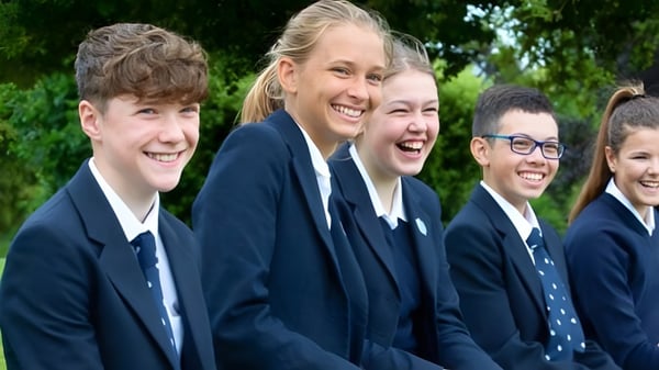 Eine Gruppe von Schülerinnen und Schülern der Stonar School steht lächelnd zusammen im grünen Außenbereich.