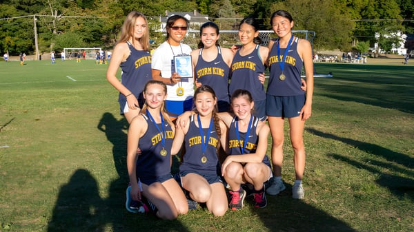 Eine Gruppe junger Athletinnen posiert gemeinsam auf einer Wiese auf dem Gelände der Storm King School.