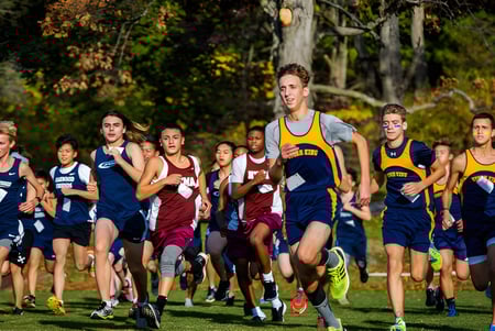 Schüler der The Storm King School laufen bei einem Cross-Country-Rennen durch einen herbstlichen Wald.