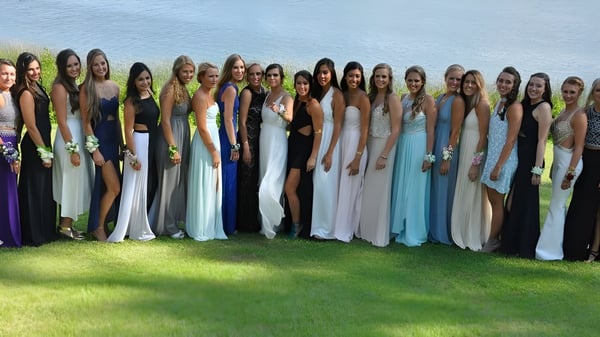 Eine Gruppe von Schülerinnen der Stouffville District Secondary School steht auf einer Wiese unter blauem Himmel.