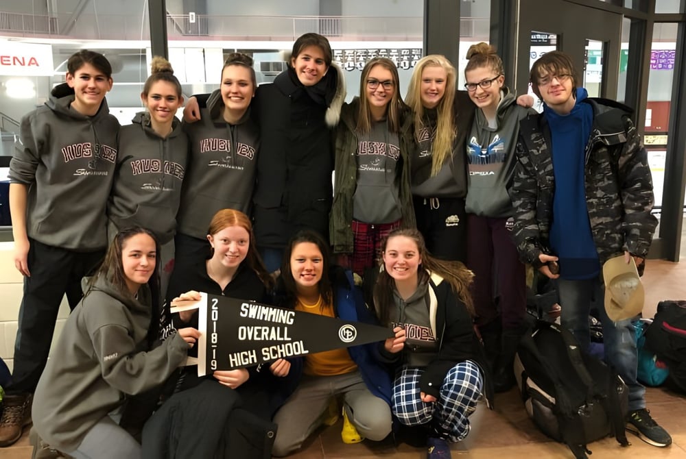Eine Gruppe Schüler der Stratford District Secondary School posiert gemeinsam in einer Sportarena.