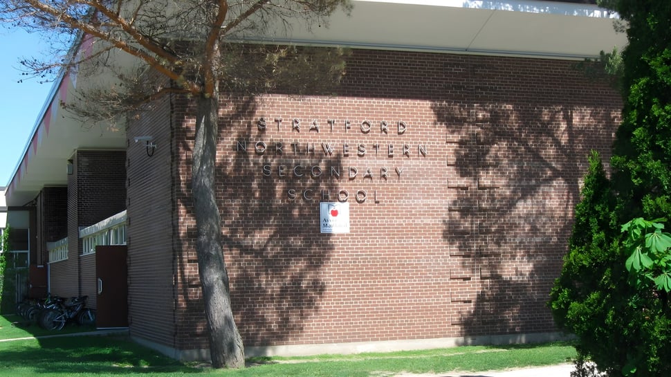 Das Backsteingebäude der Stratford District Secondary School ist von Bäumen und Grün umgeben.