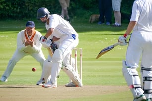 Schüler der Strathallan School spielen ein Cricketmatch auf einem grasbewachsenen Spielfeld.