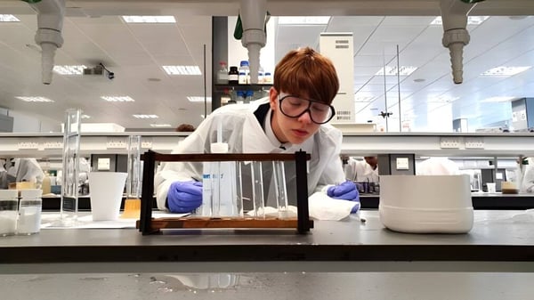 Eine Person im weißen Kittel führt in einem Labor der Strathallan School ein Experiment durch.