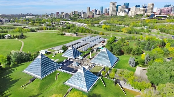 Die Architektur mit pyramidenförmigen Dächern ist vor der urbanen Skyline vom Campus der Strathcona High School zu sehen.