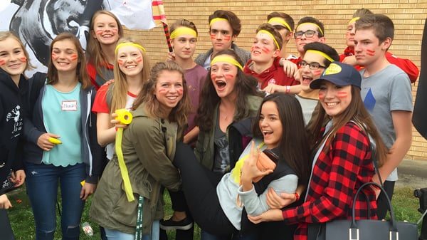 Eine Gruppe junger Schülerinnen und Schüler der Strathcona High School posiert vor einer Backsteinwand mit Graffiti.